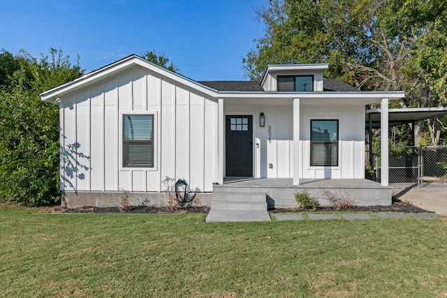 view of front facade with board and batten siding, a porch, a shingled roof, and a front yard