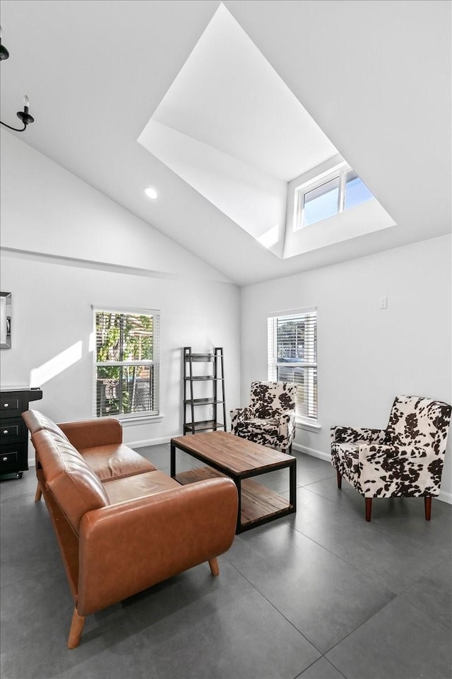 living area with baseboards, finished concrete flooring, recessed lighting, and vaulted ceiling with skylight