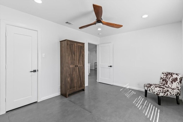 sitting room featuring finished concrete floors, a ceiling fan, visible vents, baseboards, and recessed lighting