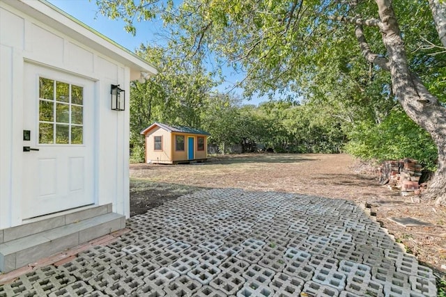 view of yard with entry steps, an outbuilding, and a shed