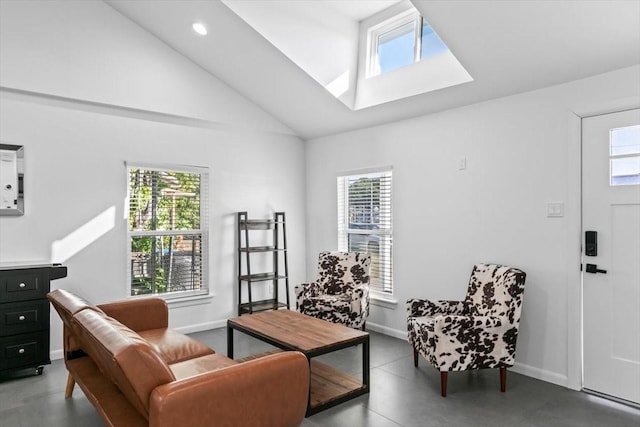 sitting room featuring plenty of natural light, baseboards, concrete flooring, and lofted ceiling with skylight