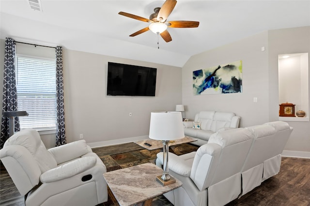living room with a ceiling fan, visible vents, baseboards, vaulted ceiling, and dark wood-style floors