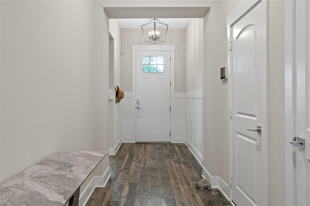 doorway to outside featuring dark wood-style flooring and a notable chandelier