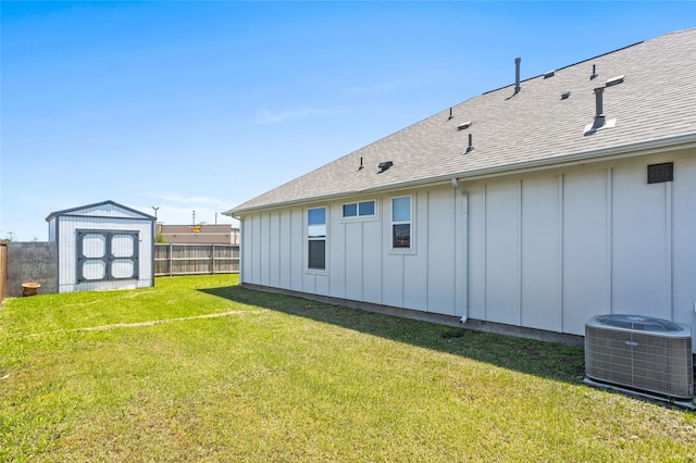 exterior space featuring central AC, an outbuilding, fence, and a storage unit