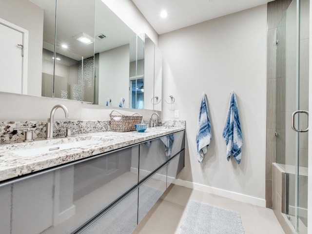 full bathroom with a shower stall, double vanity, and a sink