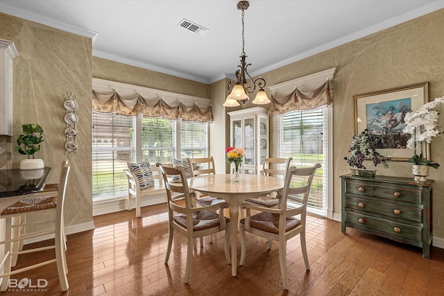 dining room featuring crown molding, wood-type flooring, plenty of natural light, and visible vents