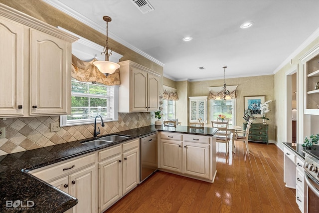 kitchen featuring pendant lighting, a sink, a peninsula, a chandelier, and appliances with stainless steel finishes