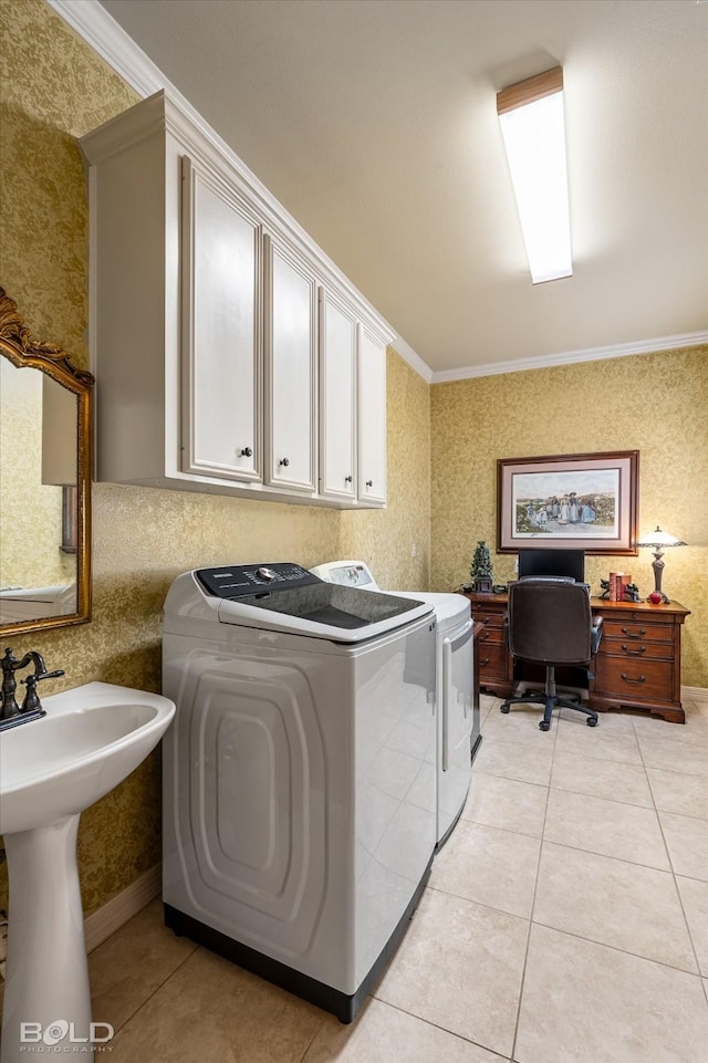 washroom with washing machine and dryer, wallpapered walls, light tile patterned floors, ornamental molding, and cabinet space