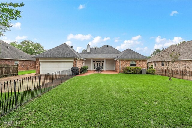 rear view of property with an attached garage, a yard, driveway, and brick siding