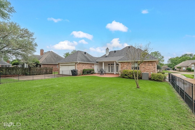 back of property featuring a yard, french doors, brick siding, and an attached garage
