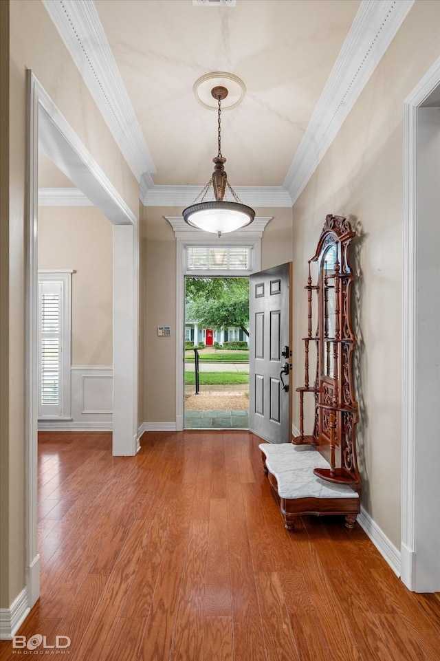 foyer entrance featuring ornamental molding and wood finished floors