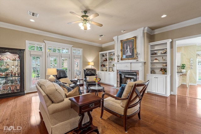 living room featuring a fireplace, a wealth of natural light, visible vents, and wood finished floors