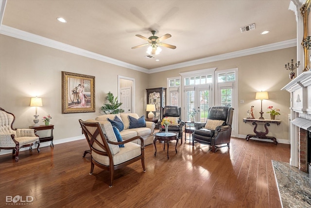 sitting room with visible vents, ceiling fan, a brick fireplace, dark wood-style floors, and baseboards