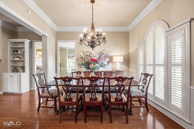 dining area featuring ornamental molding, a notable chandelier, and wood finished floors