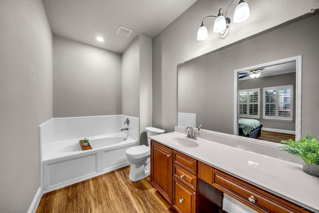 6224 Madrone Ct, Plano, TX 75074 - ensuite bathroom featuring wood finished floors, vanity, a bath, ceiling fan, and toilet