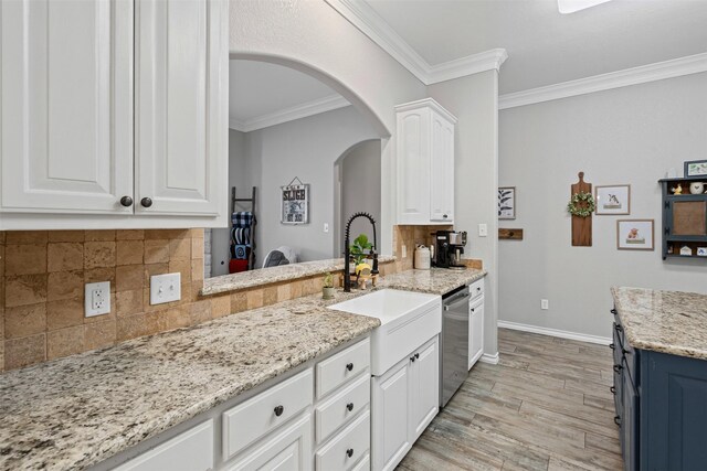 kitchen with white cabinets, dishwasher, arched walkways, and crown molding