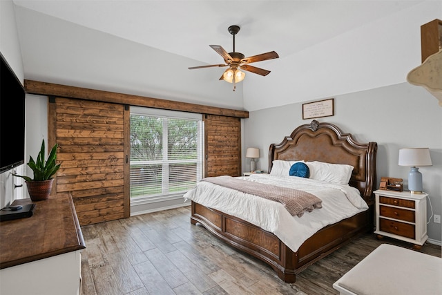 bedroom with lofted ceiling, a ceiling fan, and wood finished floors