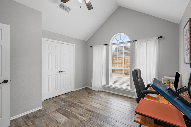 office space featuring wood finished floors, high vaulted ceiling, visible vents, baseboards, and ceiling fan