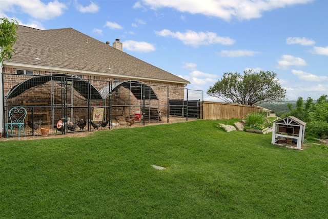 back of house featuring exterior structure, an outdoor structure, a chimney, and brick siding