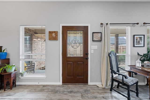 foyer entrance featuring baseboards and wood finished floors