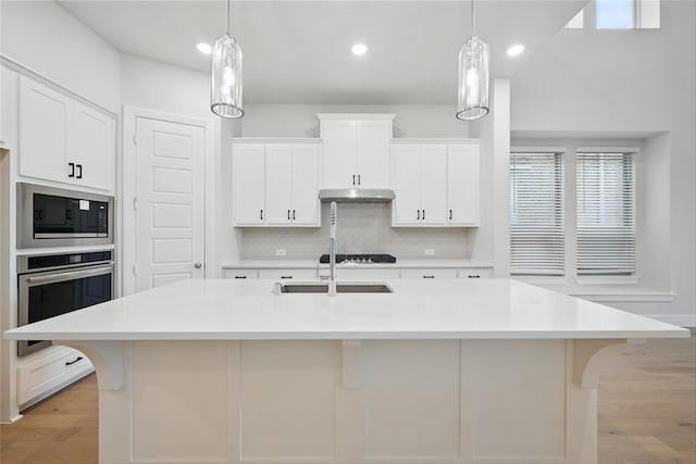 kitchen featuring stainless steel oven, tasteful backsplash, light countertops, and built in microwave