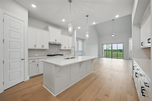 kitchen with light countertops, black cooktop, light wood-style flooring, and a sink