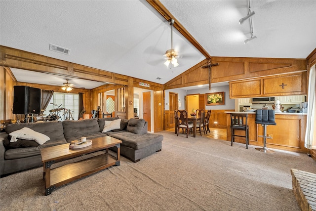 living room with rail lighting, a textured ceiling, visible vents, and ceiling fan