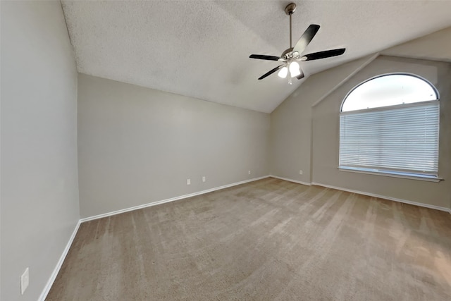 carpeted empty room featuring a ceiling fan, lofted ceiling, a textured ceiling, and baseboards