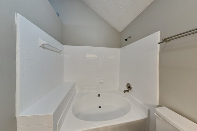 bathroom featuring toilet, lofted ceiling, and a textured ceiling