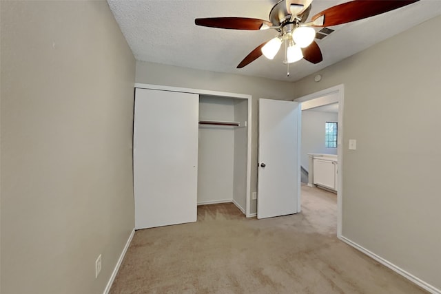unfurnished bedroom with baseboards, a closet, ceiling fan, and light colored carpet