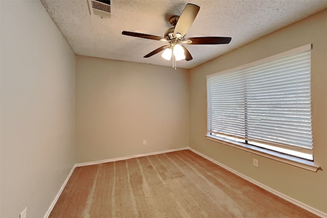 unfurnished room with a ceiling fan, baseboards, and a textured ceiling