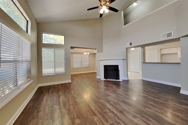 unfurnished living room featuring visible vents, baseboards, ceiling fan with notable chandelier, and high vaulted ceiling