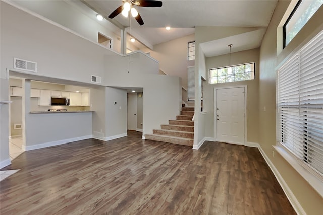 foyer entrance featuring ceiling fan, visible vents, and high vaulted ceiling