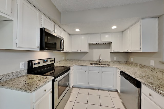 kitchen featuring a sink, light tile patterned flooring, white cabinets, and appliances with stainless steel finishes