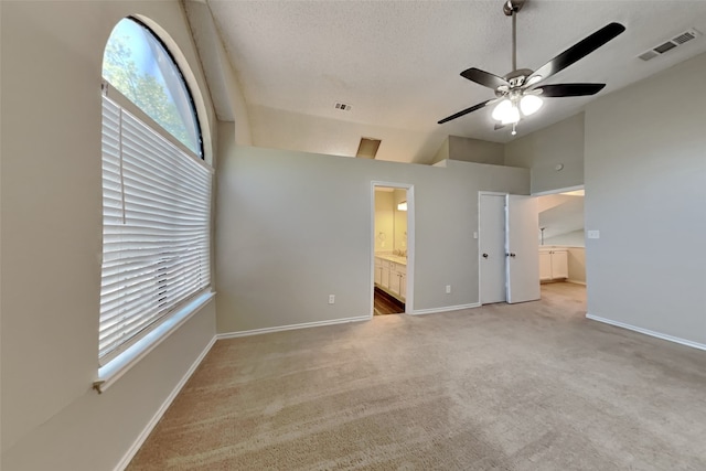 unfurnished bedroom with lofted ceiling, light carpet, baseboards, and visible vents