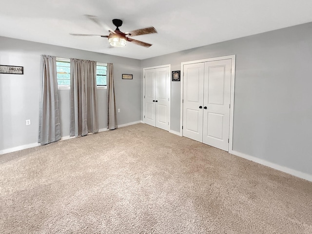 unfurnished bedroom with carpet floors, baseboards, and multiple closets