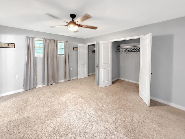 unfurnished bedroom with carpet, a closet, baseboards, and ceiling fan
