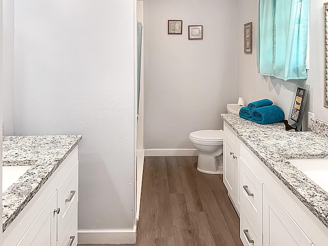 full bath featuring vanity, toilet, baseboards, and wood finished floors