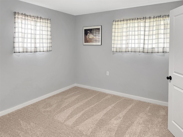 empty room featuring carpet floors and baseboards