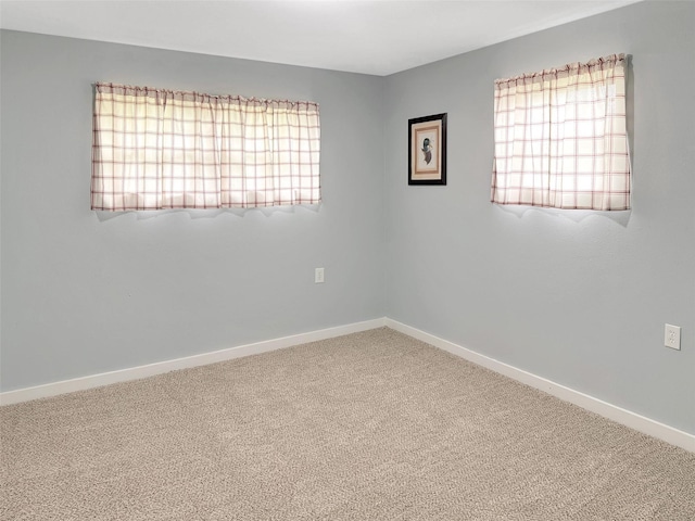 carpeted spare room with a wealth of natural light and baseboards