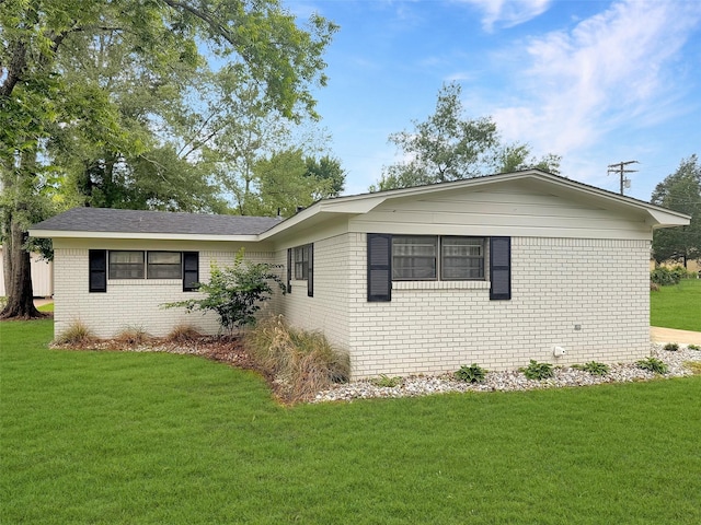 view of home's exterior featuring brick siding and a lawn
