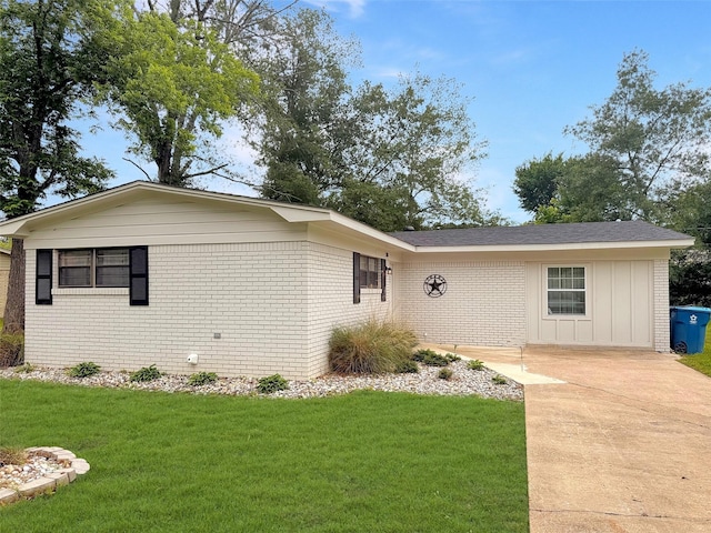 single story home featuring board and batten siding, brick siding, and a front lawn