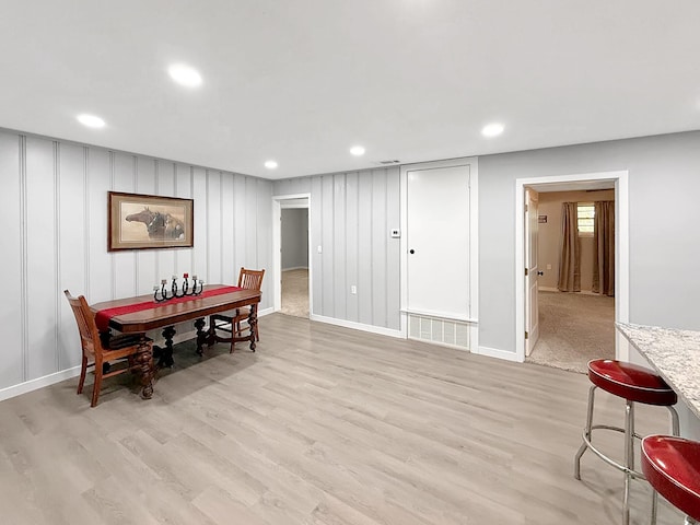dining space featuring light wood finished floors, baseboards, and recessed lighting
