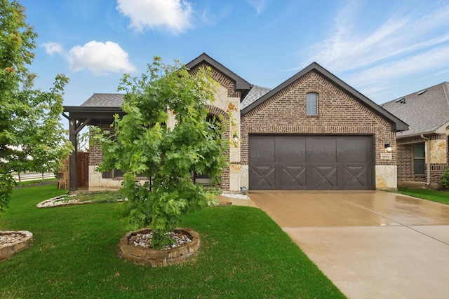 french provincial home featuring an attached garage, stone siding, a front lawn, brick siding, and driveway