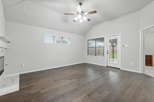 unfurnished living room with dark wood-style floors, lofted ceiling, baseboards, and a ceiling fan