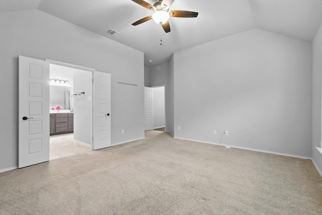 unfurnished bedroom with visible vents, baseboards, ensuite bath, light carpet, and lofted ceiling