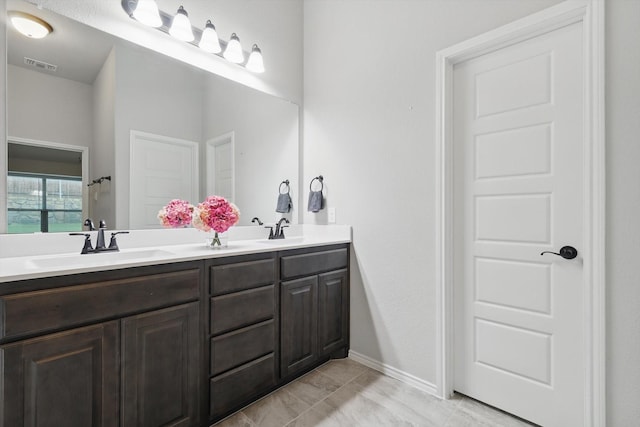 bathroom featuring a sink, double vanity, and visible vents