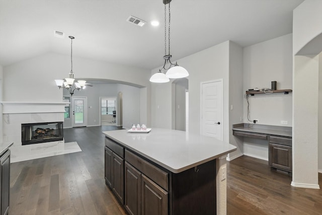 kitchen featuring visible vents, dark brown cabinetry, arched walkways, light countertops, and dark wood-style floors