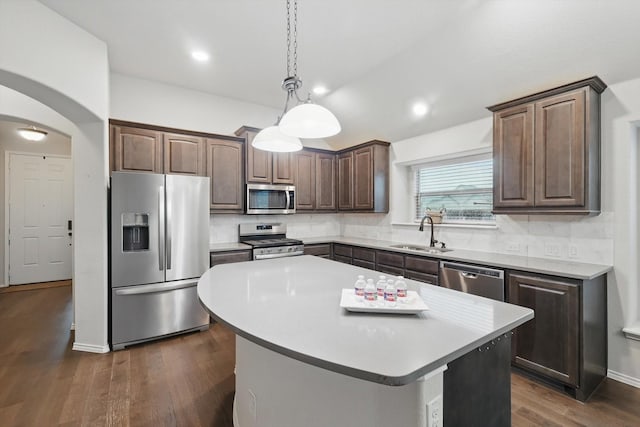 kitchen with backsplash, stainless steel appliances, dark wood-style flooring, and a sink