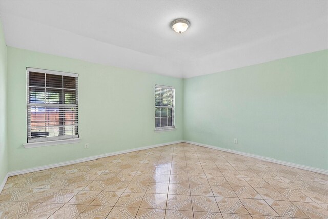908 E Belknap St, Ennis, TX 75119 - tiled empty room featuring baseboards
